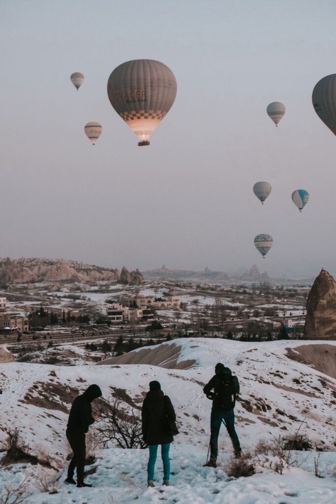 Balon udara terbang di atas Cappadocia yang tertutup salju pada musim dingin